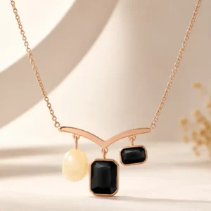 Front view of Nazar Grace anti-tarnish pendant necklace with two black stones and a pearl-inspired white accent