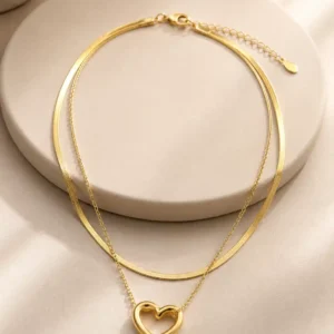 Full view of Amora Duo double-layer gold-tone heart pendant necklace arranged on an ivory jewellery stand