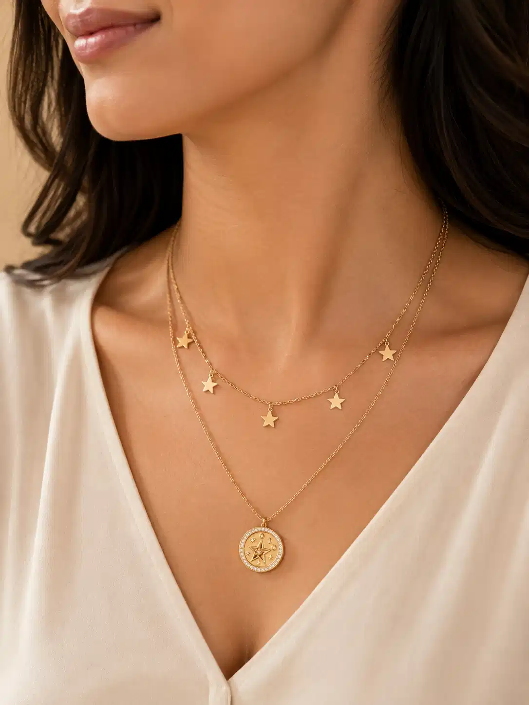 Woman wearing the Lunara gold-tone star layered necklace with a white V-neck blouse