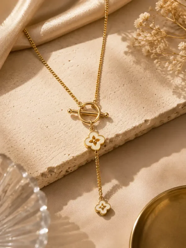 Fiora gold-tone Y-drop necklace with two ivory floral charms and a circular toggle-style centrepiece