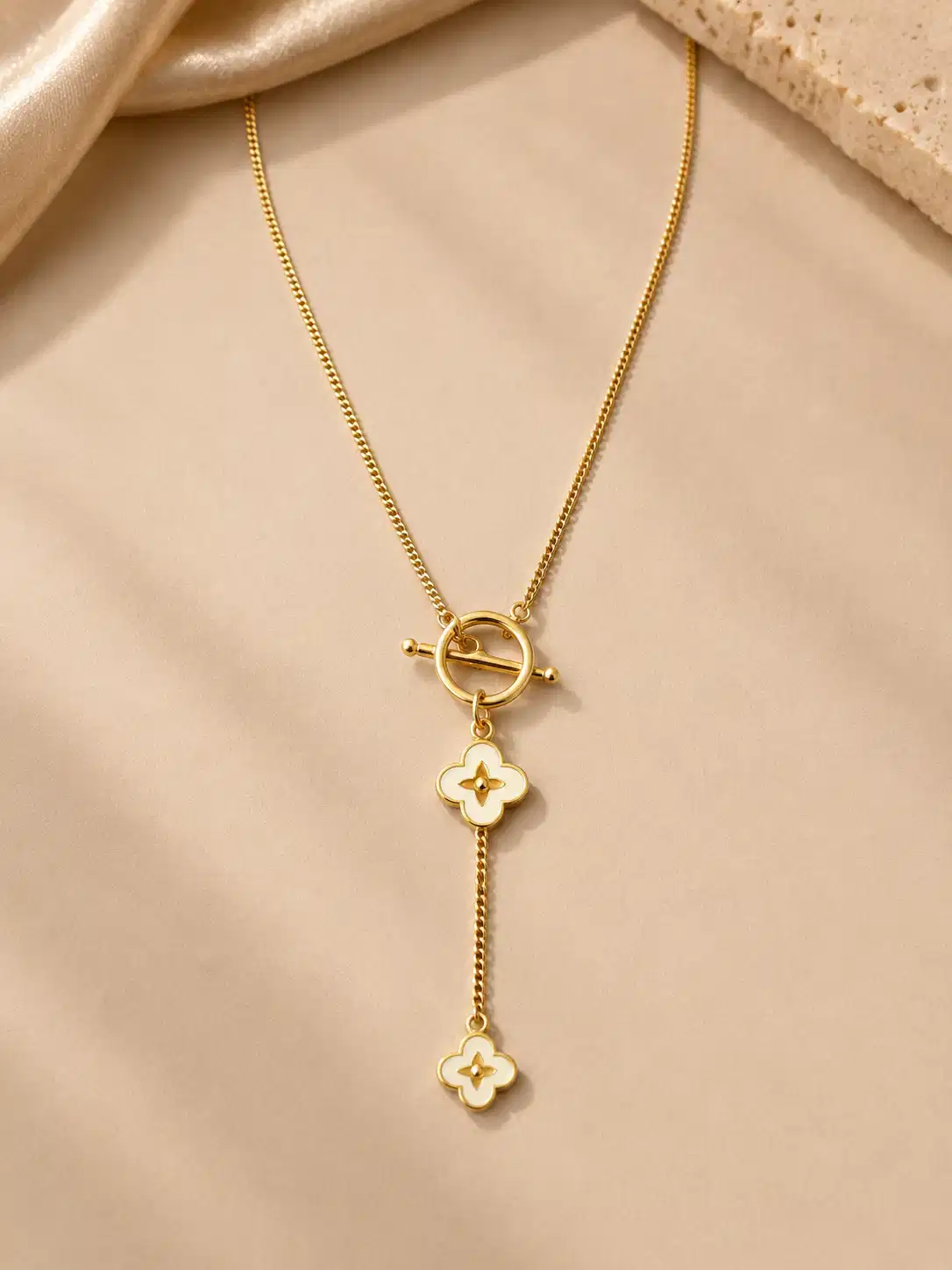 Front view of the Fiora ivory bloom Y necklace with a gold-tone chain and two graduated flower charms