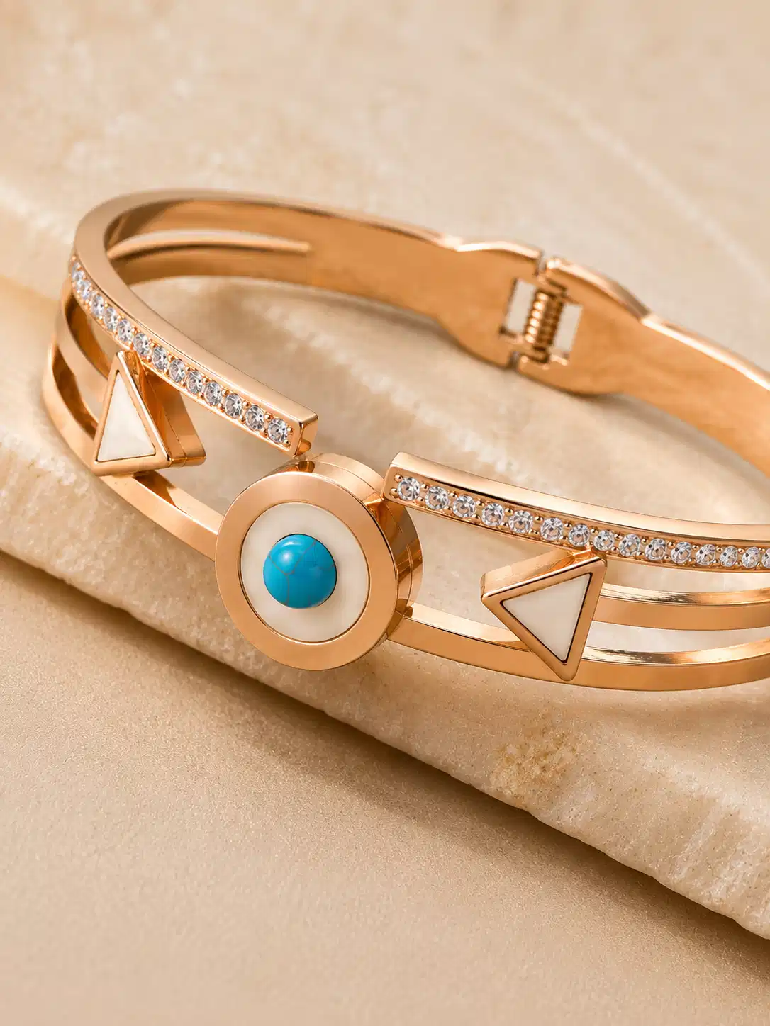 Close-up of the Veyra bangle’s turquoise-blue medallion, ivory triangles and clear stone-style row