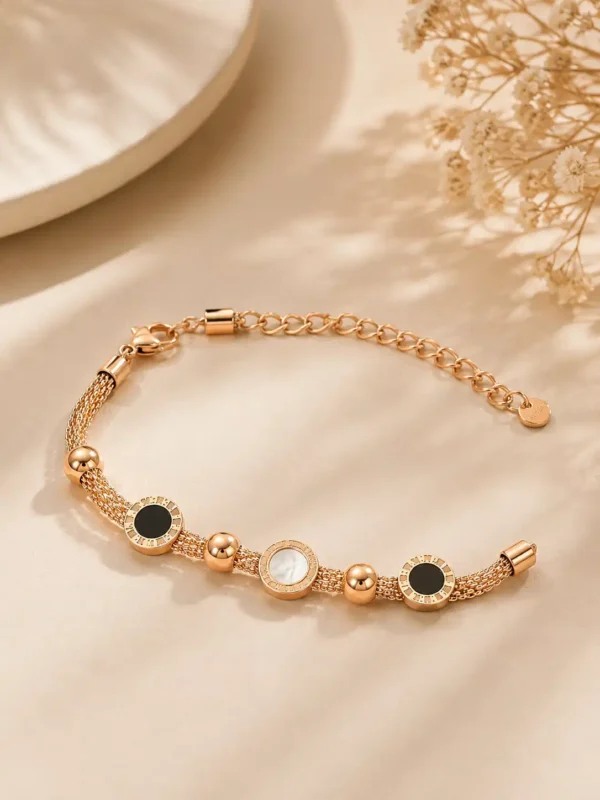 Mirelle rose-gold-tone multi-strand bracelet with black and ivory circular accents and an adjustable clasp