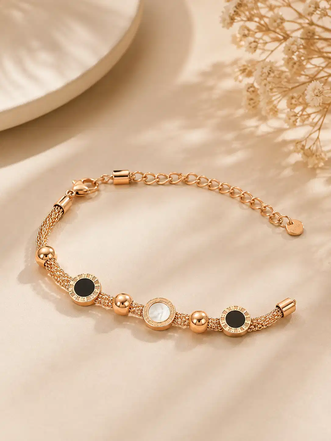 Mirelle rose-gold-tone multi-strand bracelet with black and ivory circular accents and an adjustable clasp