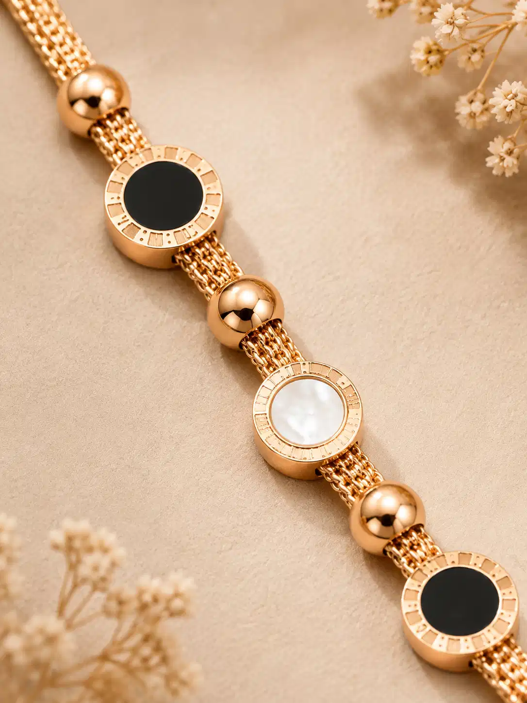 Close-up of black and ivory circular motifs with textured borders on the Mirelle rose-gold-tone bracelet