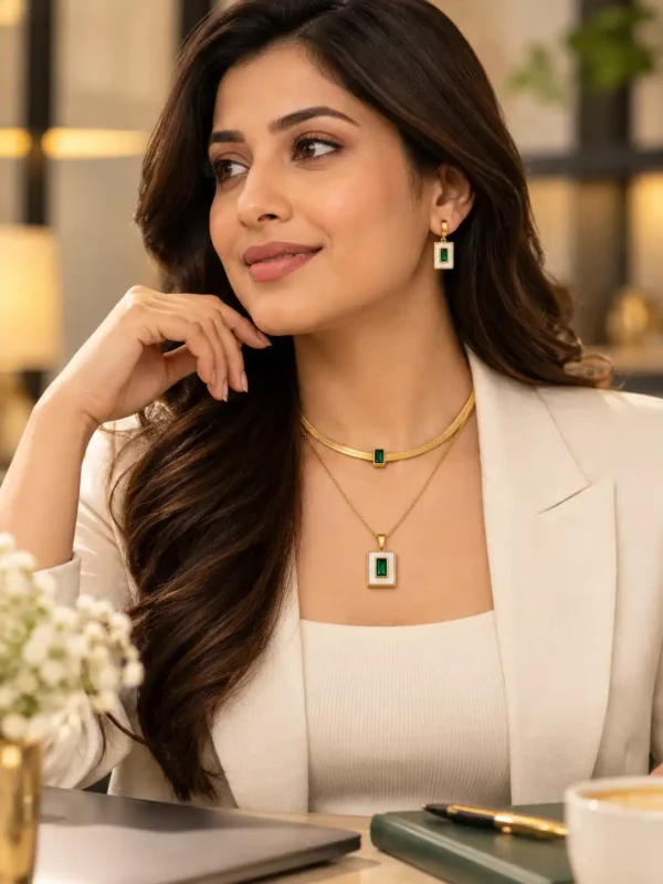 Professional woman wearing a green and gold layered necklace set with matching earrings and a white blazer