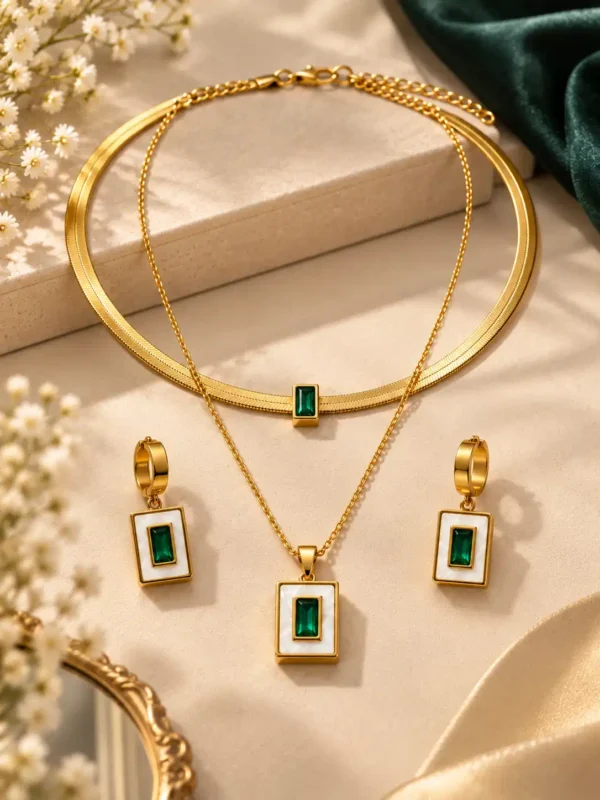 Gold-tone double-layer necklace with emerald-green pendant and matching rectangular drop earrings displayed together