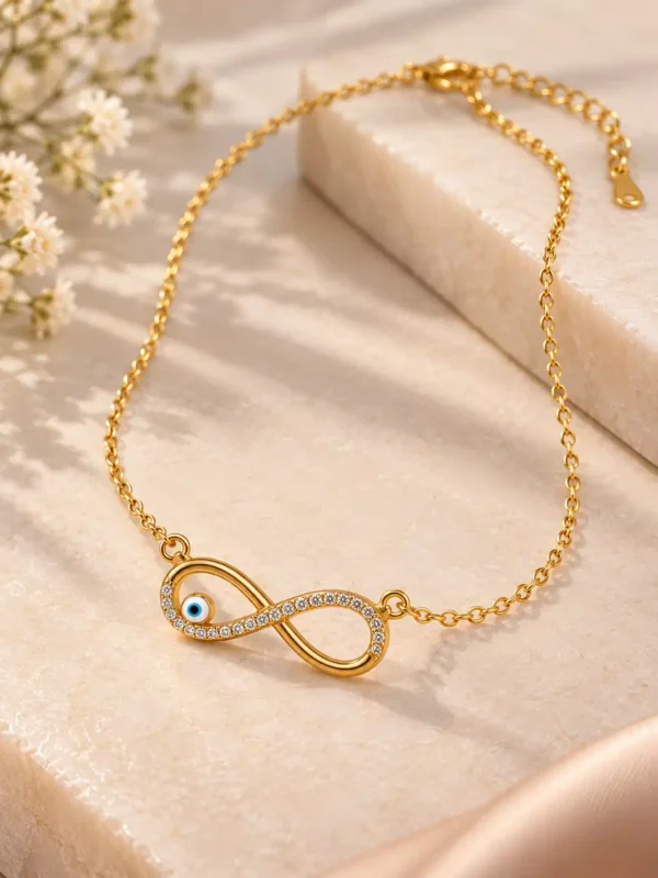 Gold-tone infinity nazar necklace laid flat with fine chain, lobster clasp and extension links