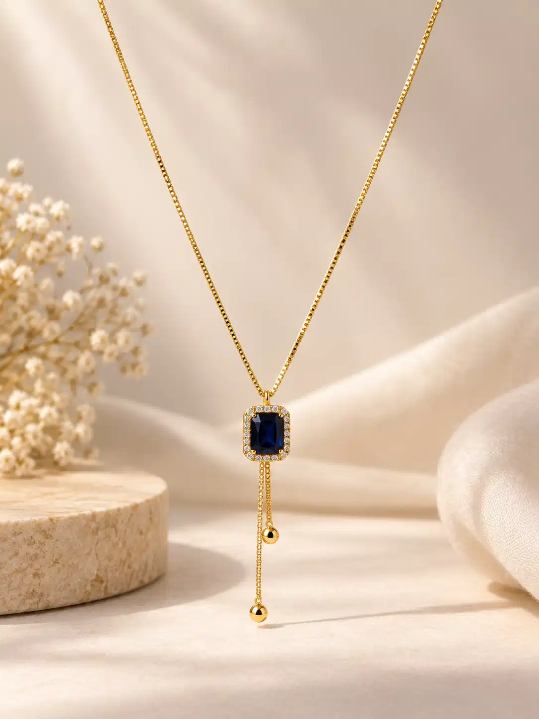 Gold-tone Y-drop necklace for women with deep blue rectangular crystal pendant and two delicate hanging bead drops