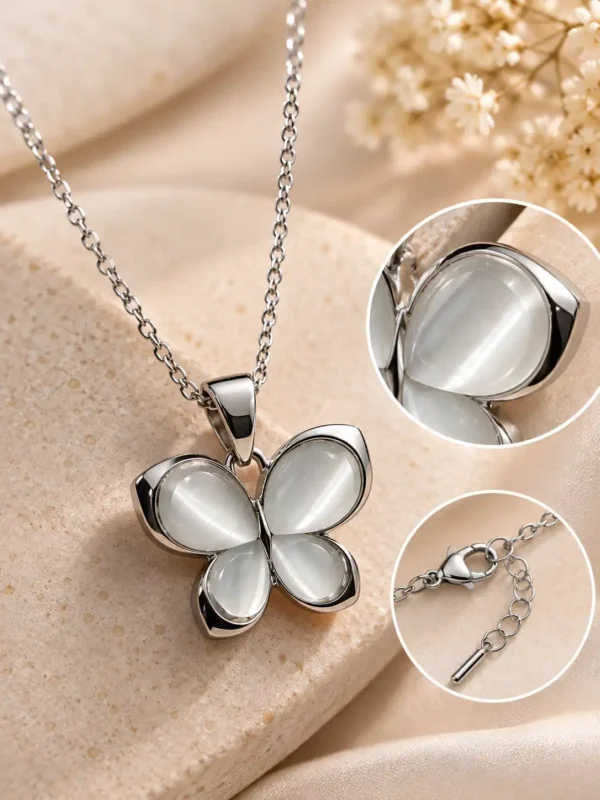 Close-up of Luna Glow butterfly pendant showing luminous white wings, polished silver frame, lobster clasp and extension chain