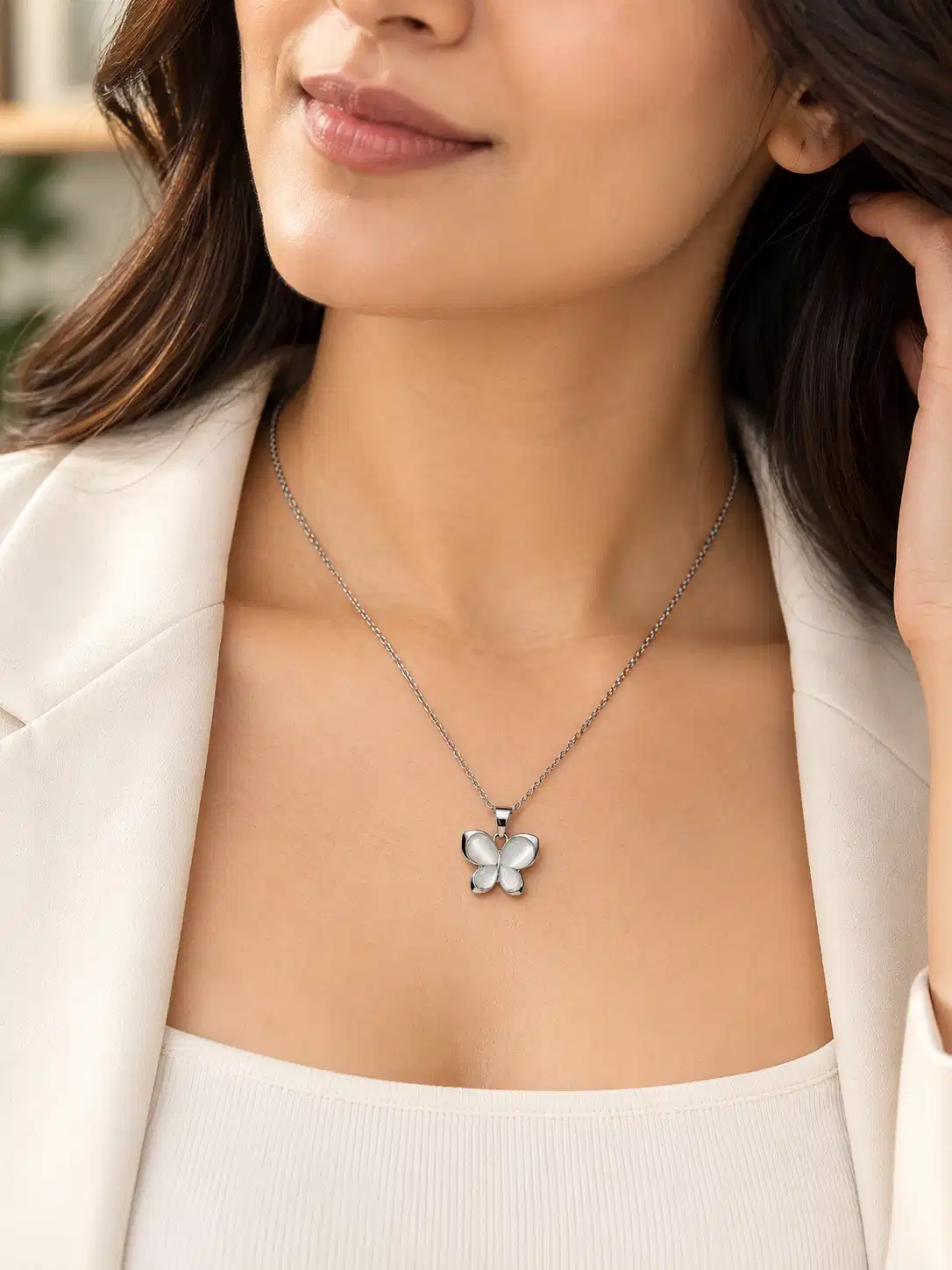 Woman wearing Luna Glow silver butterfly pendant necklace with white blazer for elegant daily and office wear