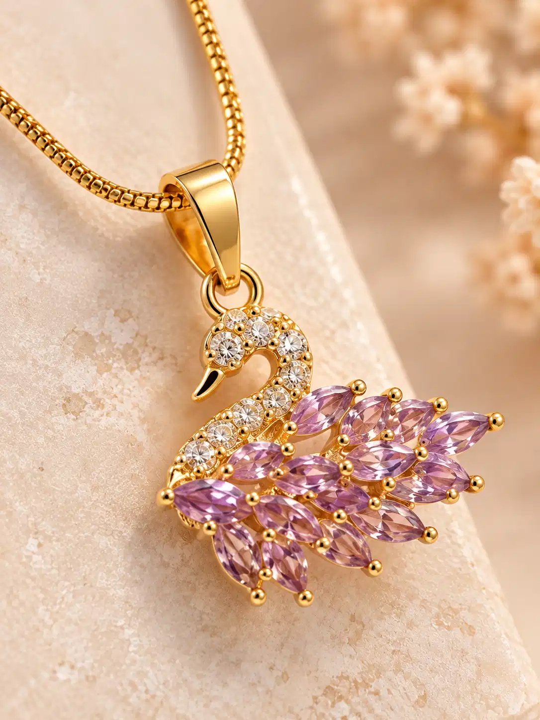 Close-up of swan pendant with blush pink marquise feather stones, clear crystals and gold-tone detailing