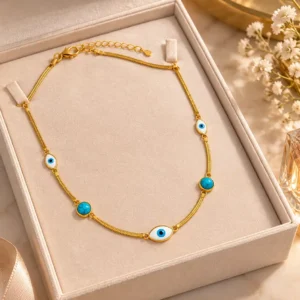Gold-tone evil eye necklace with turquoise accents displayed inside an elegant jewellery gift box