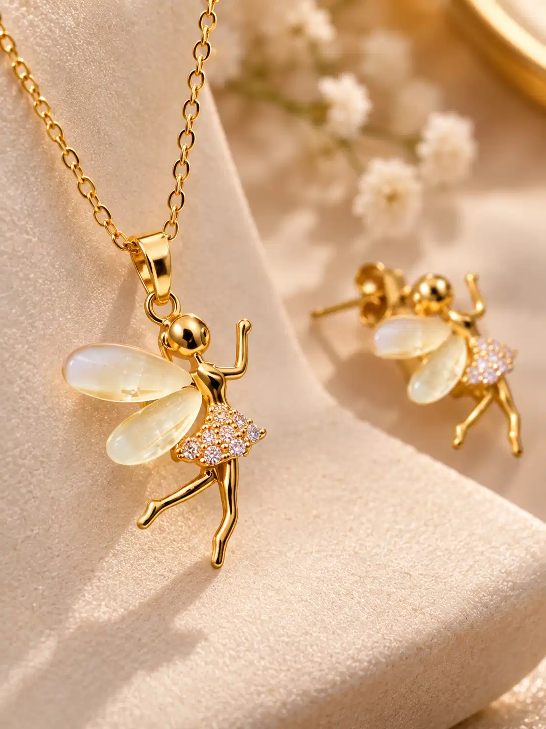 Close-up of Aurelia gold fairy pendant with translucent ivory wings and clear crystal-style embellished dress