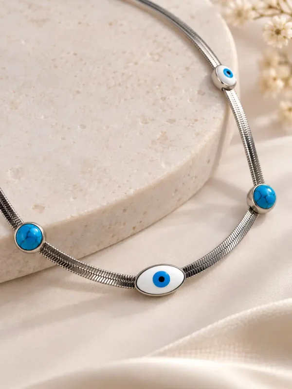 Close-up of silver evil eye necklace with white blue nazar motif and turquoise-style accents