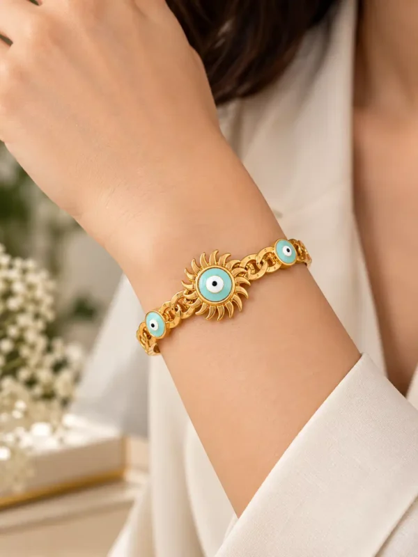 Woman wearing a gold-tone evil eye statement bracelet with turquoise sunburst nazar centre and matching side motifs.