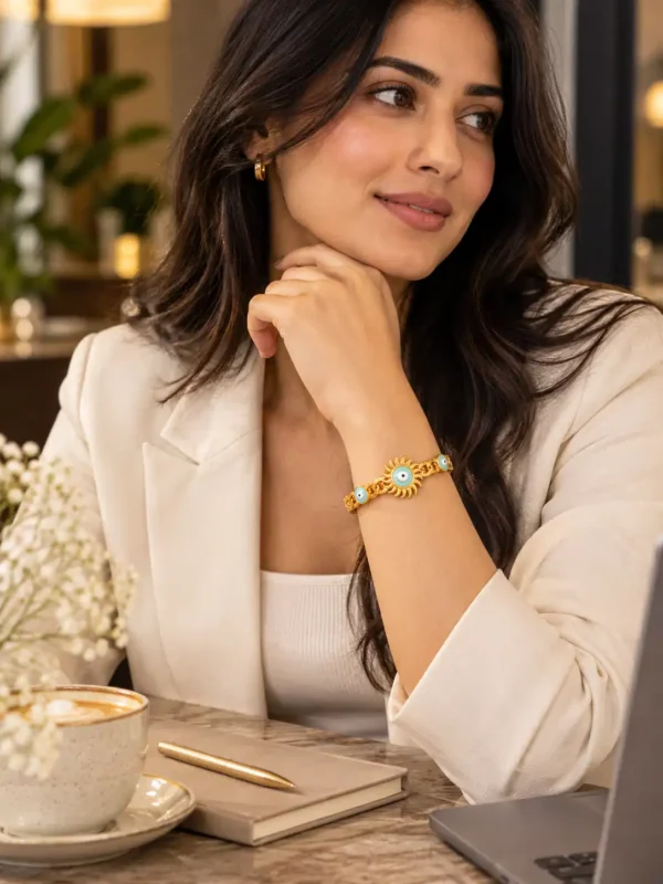 Woman in a white blazer wearing a gold turquoise evil eye bracelet for an elegant office and everyday jewellery look.