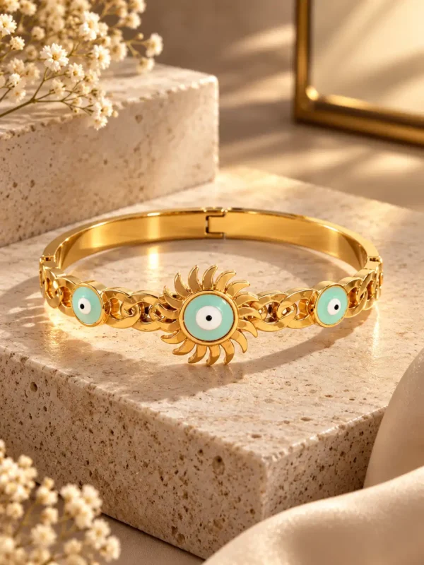 Solara turquoise nazar gold bangle displayed on a stone platform with three evil-eye motifs and sculpted sunburst detailing.