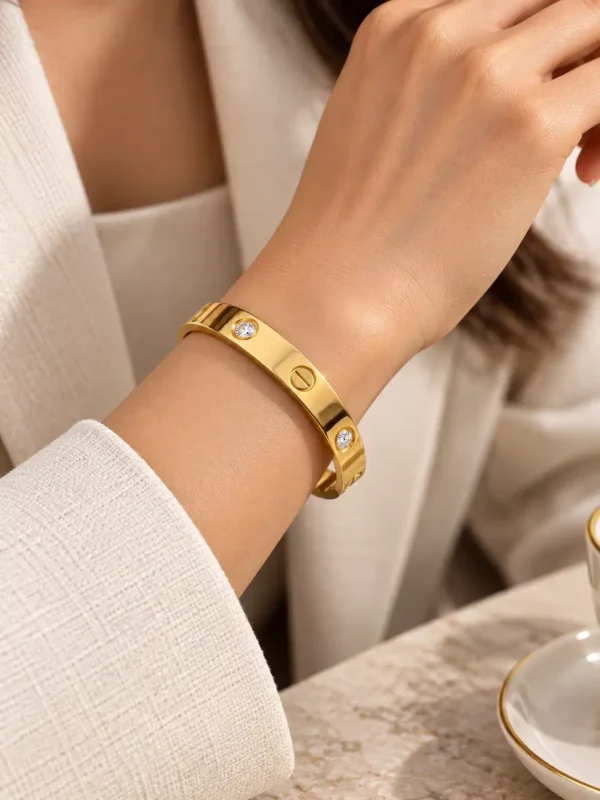 Woman wearing Aurelia minimal gold crystal bangle with white office outfit for polished everyday wrist styling.