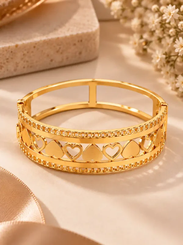Front view of wide gold heart bangle for women with open and solid heart lattice design